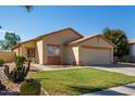 Cozy home with desert landscaping, mature trees, and a two-car garage in a quiet neighborhood at 15558 N 136Th Ln, Surprise, AZ 85374