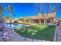 Expansive backyard boasts a sparkling pool, verdant lawn, mature trees, and ample space for recreation and relaxation at 16402 N 48Th Way, Scottsdale, AZ 85254