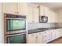 Close up view of modern kitchen with built-in oven, gas cooktop, and white marble backsplash at 1777 E Dubois Ave, Gilbert, AZ 85298