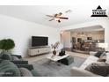 Bright living room showcasing an open-concept design with view into the kitchen and a ceiling fan at 1777 E Dubois Ave, Gilbert, AZ 85298