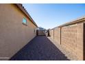 A side yard between two homes with a gravel covering and block wall fence at 19202 W Jackson St, Buckeye, AZ 85326