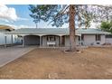 Charming single-story home featuring a carport, covered front porch and mature landscaping at 1925 W Wood Dr, Phoenix, AZ 85029