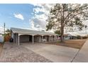 Charming single-story home featuring a carport, covered front porch and mature landscaping at 1925 W Wood Dr, Phoenix, AZ 85029