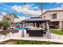 Backyard view featuring outdoor gazebo with seating area and a swimming pool with a waterfall feature at 19349 W Oregon Ave, Litchfield Park, AZ 85340