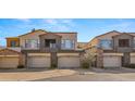 Beautiful townhome exterior with stone accents, multiple garages, and desert landscaping at 19550 N Grayhawk Dr # 2038, Scottsdale, AZ 85255