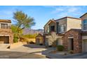 Exterior view of the townhome with mountain views, stone accents, and desert landscaping at 19550 N Grayhawk Dr # 2038, Scottsdale, AZ 85255