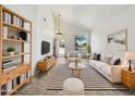 Bright living room featuring vaulted ceiling, modern furnishings, stylish rug, and large window views at 19603 N Toya St, Maricopa, AZ 85138