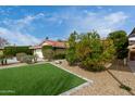 Well-maintained front yard with green lawn, mature trees, and beautiful landscaping at 212 W Interlacken Dr, Phoenix, AZ 85023