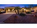 Charming home exterior with a desert landscape, a two-car garage, and an arched entryway at 23236 N Caleta Ct, Sun City West, AZ 85375