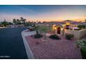 Exterior shot of a well-manicured front yard, landscaped for minimal water use, and an arched entryway at 23236 N Caleta Ct, Sun City West, AZ 85375