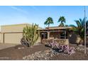 A single story home with desert landscaping, gravel, rocks, a pergola, and palm trees in the front yard at 26405 S Lakewood Dr, Sun Lakes, AZ 85248