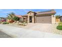 Charming single-story home featuring a two car garage, beautiful desert landscaping, and a stone facade at 26578 W Piute Ave, Buckeye, AZ 85396