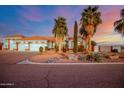 Charming desert home featuring lush landscaping, a red tiled roof, and an attached three-car garage at 2903 S 271St Ln, Buckeye, AZ 85326