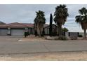 Beautiful single-story home showcasing desert landscaping and mature palm trees, enhancing its curb appeal at 2903 S 271St Ln, Buckeye, AZ 85326