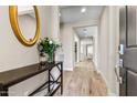 Inviting hallway featuring sleek wood floors, elegant console table, and a decorative mirror at 29304 N Horton Creek Trl, Rio Verde, AZ 85263