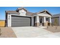 Charming single-story home featuring a two-car garage, neutral stucco, and stone-accented pillars at 42490 W Vincent Dr, Maricopa, AZ 85138