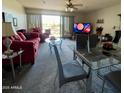 Bright living room features a sliding door to a balcony and neutral-colored carpet at 425 S Parkcrest -- # 323, Mesa, AZ 85206