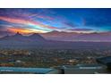 Panoramic view of a vibrant cityscape nestled against a backdrop of majestic mountains at sunset at 42613 N 111Th Pl, Scottsdale, AZ 85262