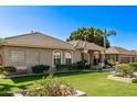 Well-manicured front yard with lush green grass, mature trees, and charming exterior details at 4503 E Elmwood St, Mesa, AZ 85205