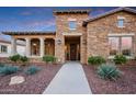 Inviting stone home featuring manicured landscaping and a welcoming front entrance at 4820 N 210Th Ave, Buckeye, AZ 85396