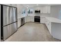 Modern white kitchen featuring stainless steel appliances, ample counter space, and a sleek design at 5432 E Juniper Ave, Scottsdale, AZ 85254