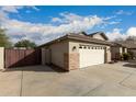 Spacious three car garage with stone accents and a large driveway on a sunny day at 6060 W Charter Oak Rd, Glendale, AZ 85304