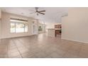 Bright living room featuring tile floors, a ceiling fan, and views of the backyard at 6060 W Charter Oak Rd, Glendale, AZ 85304