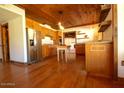 Open kitchen featuring wood cabinets, stainless steel appliances, and hardwood flooring at 9620 S 156Th Pl, Gilbert, AZ 85234