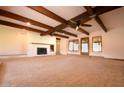 Spacious living room featuring exposed beams, a fireplace, and access to the backyard at 9620 S 156Th Pl, Gilbert, AZ 85234