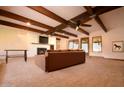 Living room featuring fireplace, exposed wood beams, carpet, and cozy seating arrangement at 9620 S 156Th Pl, Gilbert, AZ 85234