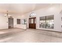 Bright living room with tile flooring, large windows, and a unique arched entryway creating an airy ambiance at 109 W Kathleen Rd, Phoenix, AZ 85023