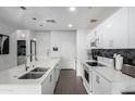 Bright kitchen boasts stainless steel appliances, a large island, and contemporary white cabinetry at 1130 N 2Nd St # 411, Phoenix, AZ 85004