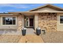 Inviting front entrance with a brick facade and decorative planters leading to a modern front door at 12806 W Jadestone Dr, Sun City West, AZ 85375