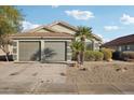 Charming single-story home featuring a three-car garage, desert landscaping, and mature palm trees at 13326 W Watson Ln, Surprise, AZ 85379