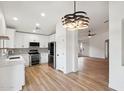 Open-concept kitchen featuring white cabinets, stainless steel appliances, and a view into the living area at 13326 W Watson Ln, Surprise, AZ 85379