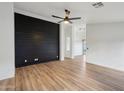 Bright living room with a modern accent wall, ceiling fan, and light wood-style flooring at 13326 W Watson Ln, Surprise, AZ 85379