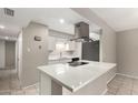 Modern kitchen featuring white cabinets, an island cooktop, and stainless steel appliances at 14408 N 35Th Ave, Phoenix, AZ 85053