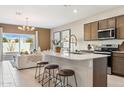 Modern kitchen featuring a large island with seating, stainless steel appliances, and plenty of cabinet space at 1531 S 239Th Dr, Buckeye, AZ 85326