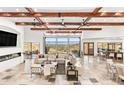 Spacious living room with exposed wood beams, a fireplace, and expansive windows showcasing scenic desert views at 15504 E Firerock Country Club Dr, Fountain Hills, AZ 85268