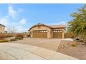 Single-story house with a three-car garage, desert landscaping, and a paver driveway at 17530 W Oberlin Way, Surprise, AZ 85387