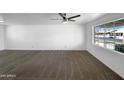 Bright living room featuring new carpet, a ceiling fan, and a large window that looks out to the neighborhood at 1801 W 5Th Pl, Mesa, AZ 85201