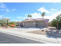 Well-manicured home featuring mature palm trees, desert landscaping, and a spacious three car garage at 18701 N Diamond Dr, Surprise, AZ 85374