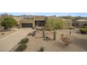 Exterior shot of a desert home with a front yard featuring native landscaping and a circular driveway at 19131 E Tonto Verde Dr, Rio Verde, AZ 85263