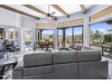 Expansive living room featuring marble floors, beamed ceilings, mountain views and comfortable gray sofas at 19131 E Tonto Verde Dr, Rio Verde, AZ 85263