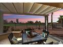 A covered patio seating area overlooks the green golf course and desert landscape at 22524 N San Ramon Dr, Sun City West, AZ 85375