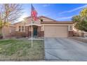 Delightful single-story home with a two-car garage, brick detailing, and lush green lawn at 38208 N La Grange Ln, San Tan Valley, AZ 85140