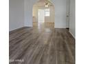 Open-concept living room with wood-look floors leading to kitchen and other living spaces at 4601 E Pollack Ln, Phoenix, AZ 85042