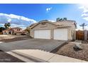 Side view of a beige home featuring a three-car garage and concrete driveway at 5145 W Tonto Rd, Glendale, AZ 85308