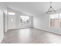 Bright, open-concept living room featuring tile floors, plenty of natural light, and a contemporary chandelier at 5145 W Tonto Rd, Glendale, AZ 85308