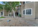 Attractive condo building with a warm, neutral color palette, accented by green trees and drought-resistant landscaping at 5230 E Brown Rd # 110, Mesa, AZ 85205